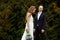 Bride with a bouquet of violet crocuses walks behind a groom