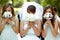 Bride and bridesmaids hide their faces behind little wedding bouqeuts