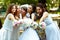 Bride and bridesmaids reach hands with bouquets to the cameraman