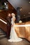 Bride in a chic long dress with a train and the groom stand on big stairs, couple in love hugs on stairs kiss and look at each