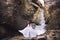 The bride in a chic wedding dress is standing on the background of a glacier