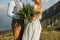 the bride closed her eyes and whispers something to her fiance, close-up, green bouquet on the background of mountains