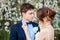 Bride corrects to groom the butterfly on the background of a flo