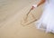 Bride drawing heart on the sand