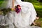 Bride dressed in white lace dress and veil with bouquet of flowers and peacock feathers