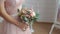 Bride in dusty pink dress. Hands with a bouquet