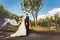 Bride with flowing veil and groom in park