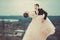 Bride and groom dancing against a cloudy sky. Happy newlywed couple in love. Wedding day. The bride and groom are twenty-five