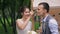 Bride and groom eat cake from one plate in front of trolley with sweets.