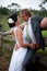 Bride and Groom embracing against a fence