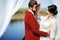 Bride and groom fooling around at photo shoot after ceremony, inside arch with white cloths fabric. Wedding Color