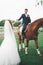 Bride and groom in forest with horses. Wedding couple. Beautiful portrait in nature