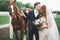 Bride and groom in forest with horses. Wedding couple. Beautiful portrait in nature