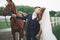 Bride and groom in forest with horses. Wedding couple. Beautiful portrait in nature