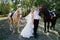 Bride and groom in forest with horses. Wedding couple .Beautiful portrait in nature