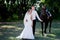 Bride and groom in forest with horses. Wedding couple .Beautiful portrait in nature