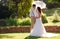 Bride and groom in garden wedding with parasol