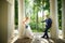 Bride and groom in gazebo near the white columns in a sunny summer day in the city park