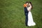 Bride and groom on green grass background