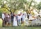 Bride, groom, guests posing for the photo at wedding reception outside in the backyard.