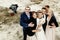 Bride and groom with happy groomsmen and bridesmaids having fun and laughing at sandy lake, luxury wedding