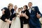 Bride and groom with happy groomsmen and bridesmaids having fun and laughing at sandy lake, thumbs up