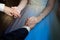 Bride and groom hold hands during the first dance, wedding rings