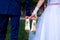 The bride and groom hold the shoes of the bride between themselves and hold hands with their little fingers. Wedding in detail