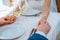 Bride and groom are holding each other\'s hand in a restaurant