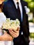 Bride and groom holding flower outdoor.