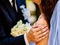 Bride and groom holding flower outdoor