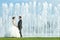 Bride and groom holding hands in front of water fountain