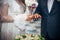 Bride and groom holding hands. Hands of the newlyweds and bride`s bouquet. Wedding concept
