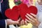 Bride and groom holding red puzzle hearts, wedding concept, closeup