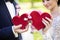 Bride and groom holding red puzzle hearts, wedding concept, closeup