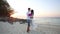 Bride and groom hug at sand beach at sunrise