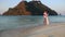 bride and groom hug standing in water against island