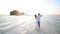 bride and groom hug in water at spit against island