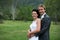 Bride and Groom hugging in a green field