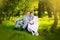 Bride and groom hugging and looking in the eyes of one another sitting at a green grass