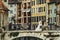 Bride and groom hugging on old romantic bridge over river and ch