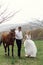 The bride and groom kiss in the stable next to the horse. A newlywed couple's sunset walk with a horse.