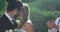 Bride and groom kissing and in background guests toss petals 4K 4k