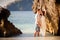 bride and groom lean against rock