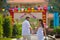 Bride and groom look at the camera, leaving the summer Park outdoors, holding hands