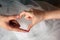 Bride and groom make a heart out of the fingers