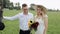 A bride and a groom near a black horse in the field