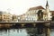 Bride and groom on old romantic bridge over river and church in