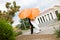 Bride and groom with orange umbrellas