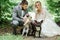 Bride and groom play with fluffy dogs standing in the forest